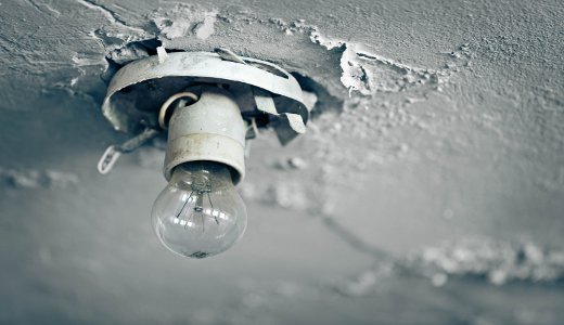The old light bulb on the ceiling of an abandoned house